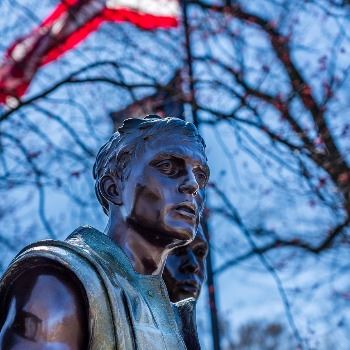 statue of vietnam-veteran with flag in background